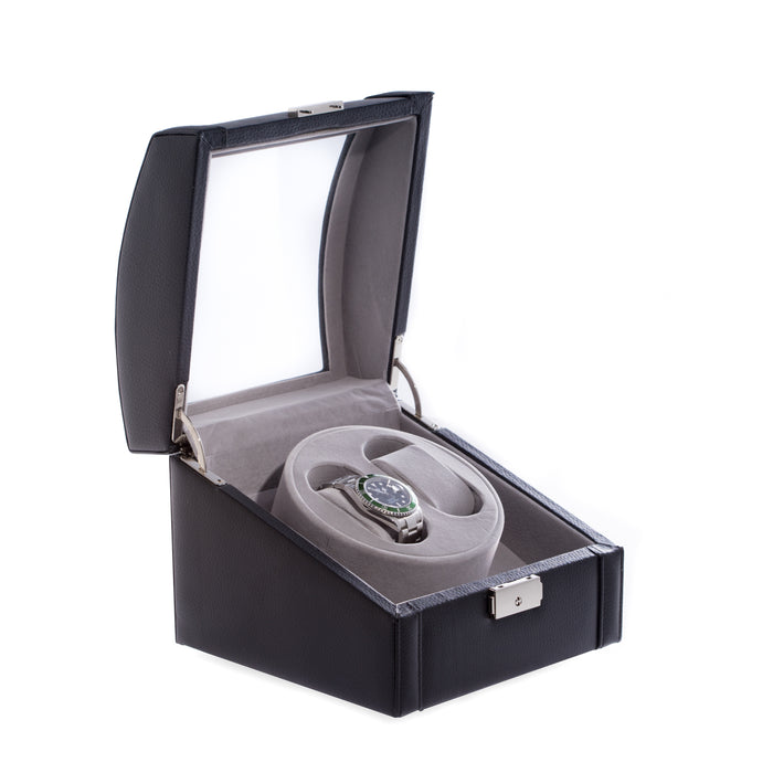 Occasion Gallery Black Leather Watch Winder w/ Glass Top & Locking Clasp. Includes Watch Pillows for Large & Small Wrist Sizes.  Single / Dual Direction Rotation. Rotates over 4300 Times a Day. Works on Both AC/DC Back Up Power. 7.25 L x 7.5 W x 6.5 H in.